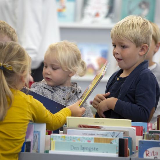 Billede af børn der sidder foran bogkasser