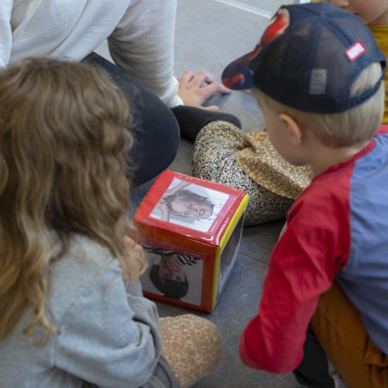 Flere børn der sidder rundt om et stykke legetøj med ord