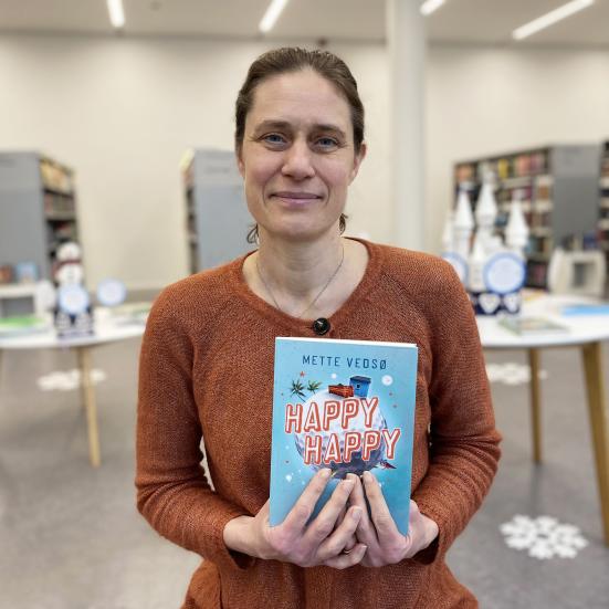 Bibliotekets børnelitteraturformidler Nicoline med Mette Vedsøs bog 'Happy Happy'