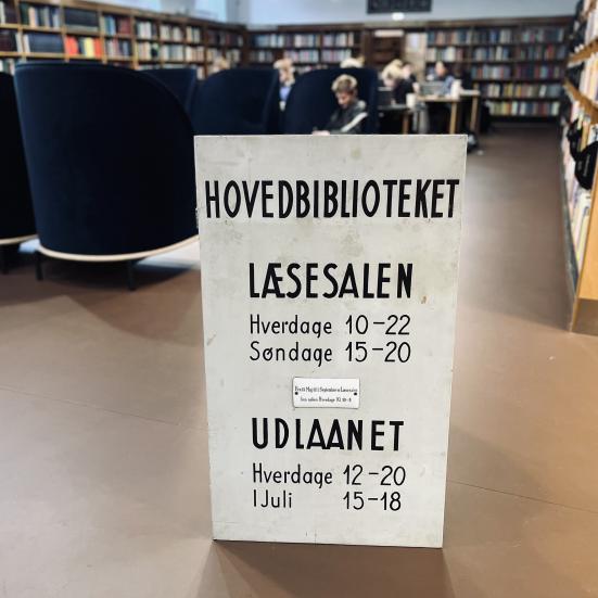 Gammelt skilt med åbningstider for læsesal og udlånet