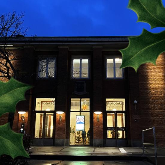 Billede af hovedbibliotekets facade taget i mørke. Tilføjet julegrafik i form af blade fra kristjørn.