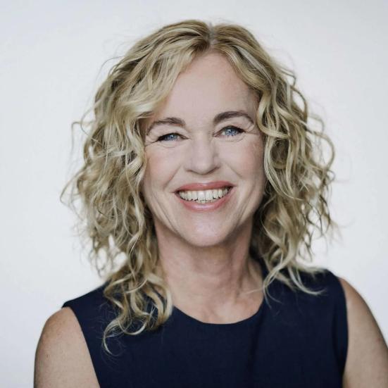 Smilende Anja C. Andersen på hvid baggrund.