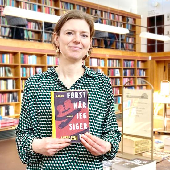 Bibliotekar stående med bogen Først når jeg siger