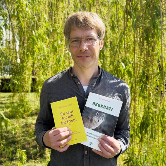 Forfattersamtale - bibliotekar står med to bøger af forfatterne