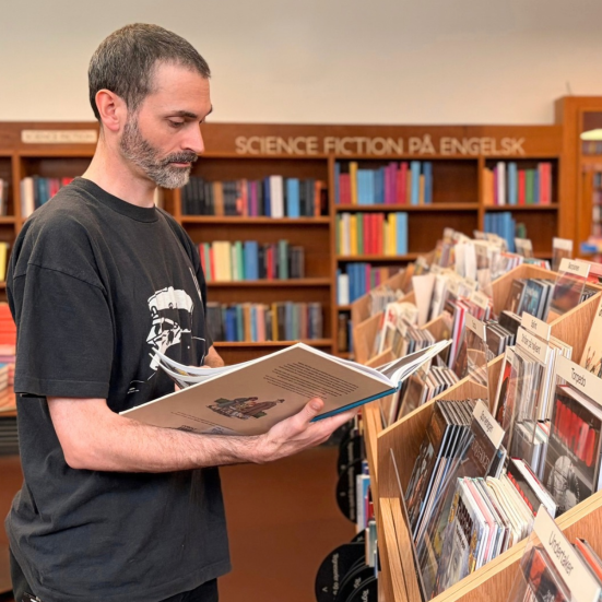 Bibliotekar ser på tegneserie ved nyt møbel i Nordsalen