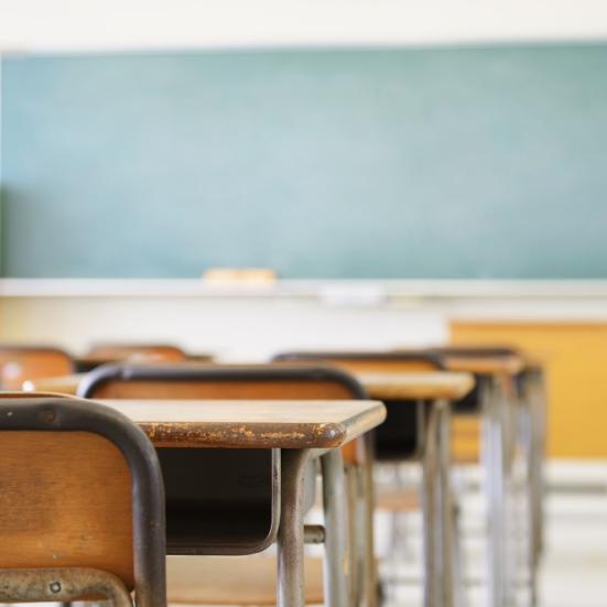 Tomt klasselokale med stole, borde og tavle