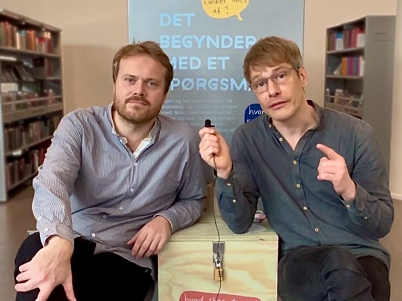 Videnskabsjournalist og bibliotekar sidder foran spørgsmålskassen på børnebiblioteket.