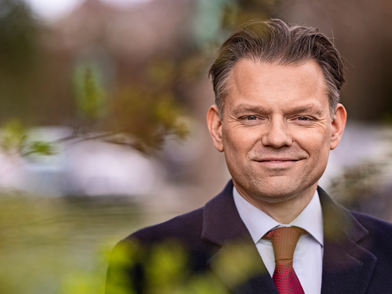 Portræt af borgmester Michael Vindfeldt der smiler. Tær på og ude i noget grøn natur. 