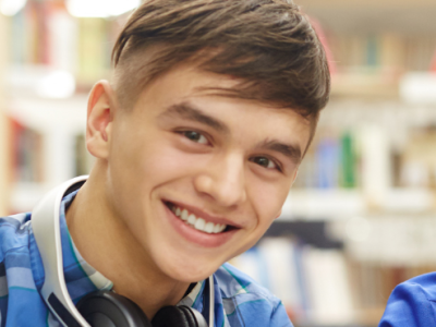 Billede af to smilende skoleelever, en dreng og en pige, der kigger ind i kameraet.