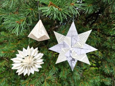 julepynt lavet af papir hænger på et grantræ