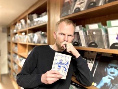 Biblioteket kulturformidler Morten står med bogen 'Om Musik' af Dan Turell