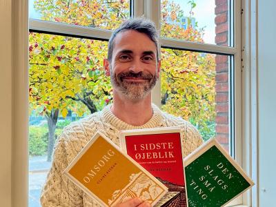 Foto viser en bibliotekar med tre bøger af Claire Keegan i hænderne