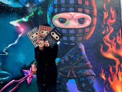 Gavlmaleri med ternet nonja og dreng der holder ternet ninja-bøger