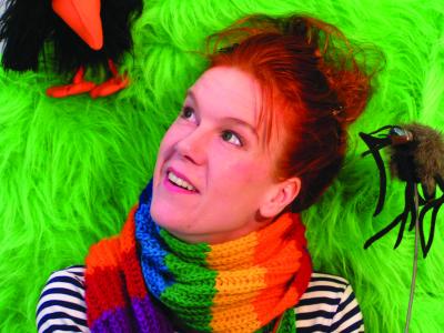 skuespiller med regnbuetørklæde og neongrøn baggrund.