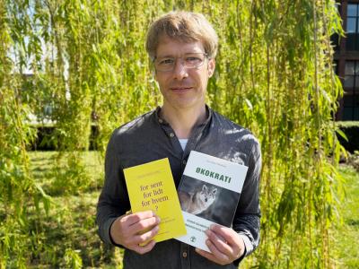 Forfattersamtale - bibliotekar står med to bøger af forfatterne