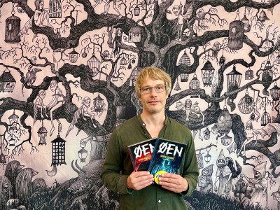 bibliotekar holder anbefalet bog. I Baggrund en tegning med et træ med monstre