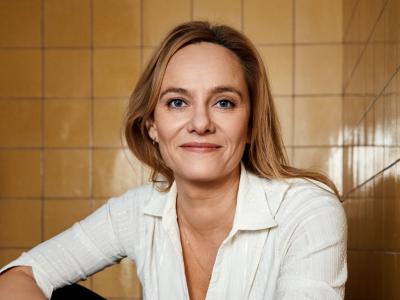Forfatter Maren Uthaug siddende foran en baggrund af hvide kakler