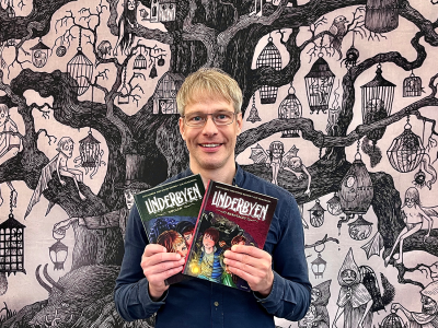 Bibliotekar holder bind 1 og bind 2 af tegneserien Underbyen 