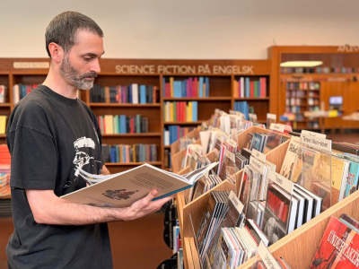 Bibliotekar ser på tegneserie ved nyt møbel i Nordsalen