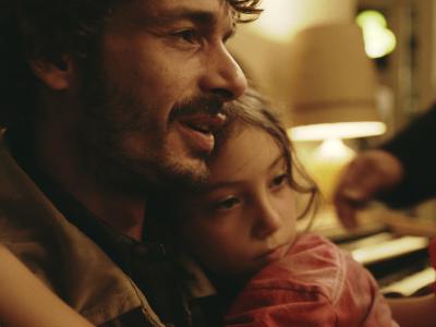 Stillbillede fra filmen med far og datter i omfavnelse.