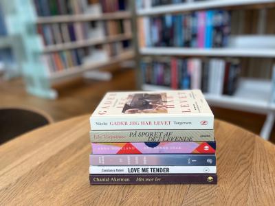 Billede af en stak bøger på et bord på et bibliotek