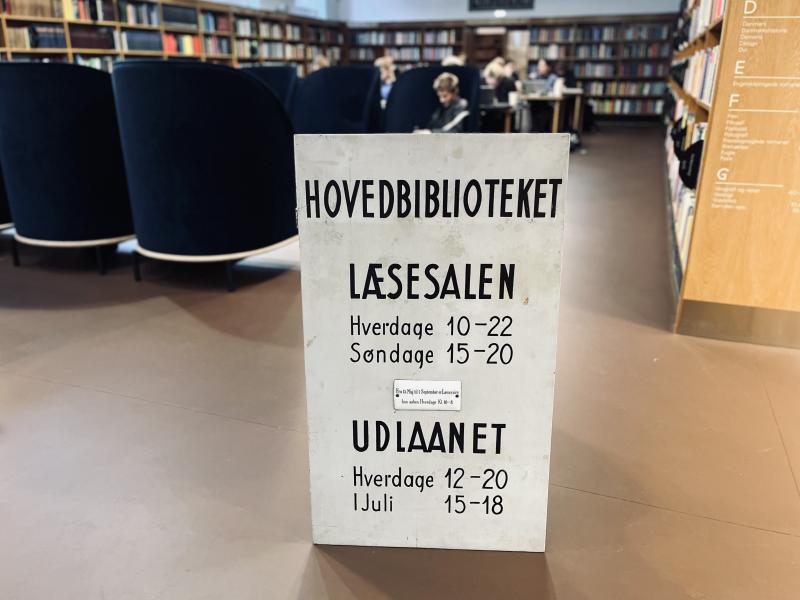 Gammelt skilt med åbningstider for læsesal og udlånet