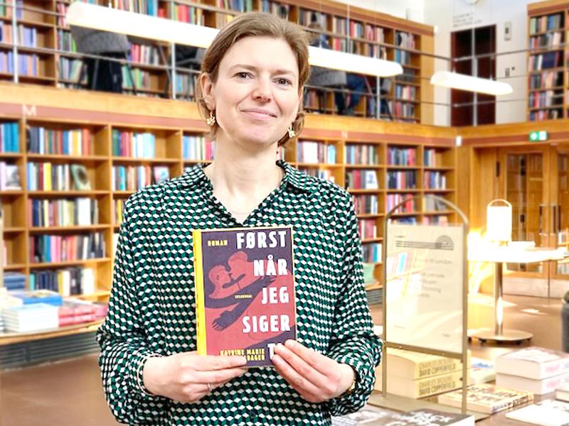 Bibliotekar stående med bogen Først når jeg siger