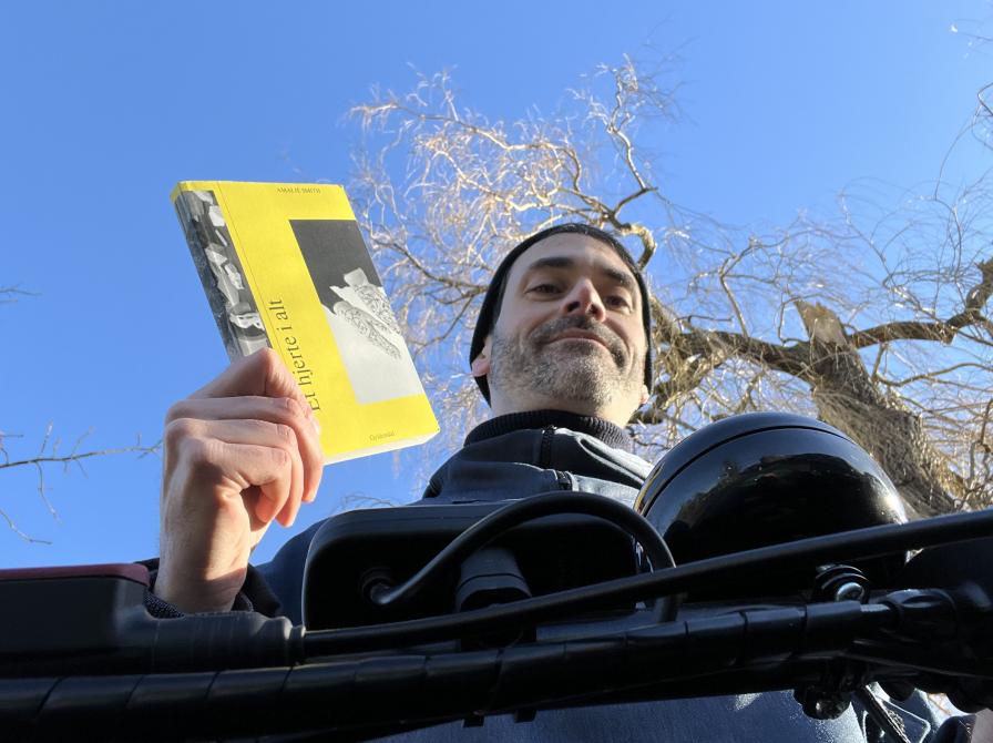 Litteraturformidler Benoit, der holder bogen 'et hjerte i alt' med blå himmel i baggrunden