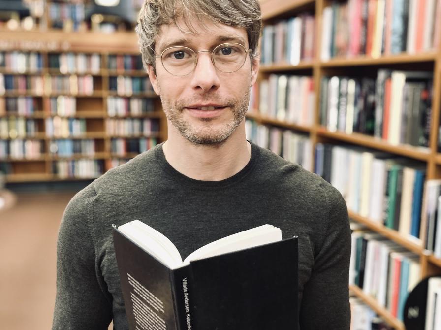 Biblioteket litteraturformidler Anders Lykke Jensen med Villads Andersens debutroman 'København udateret'