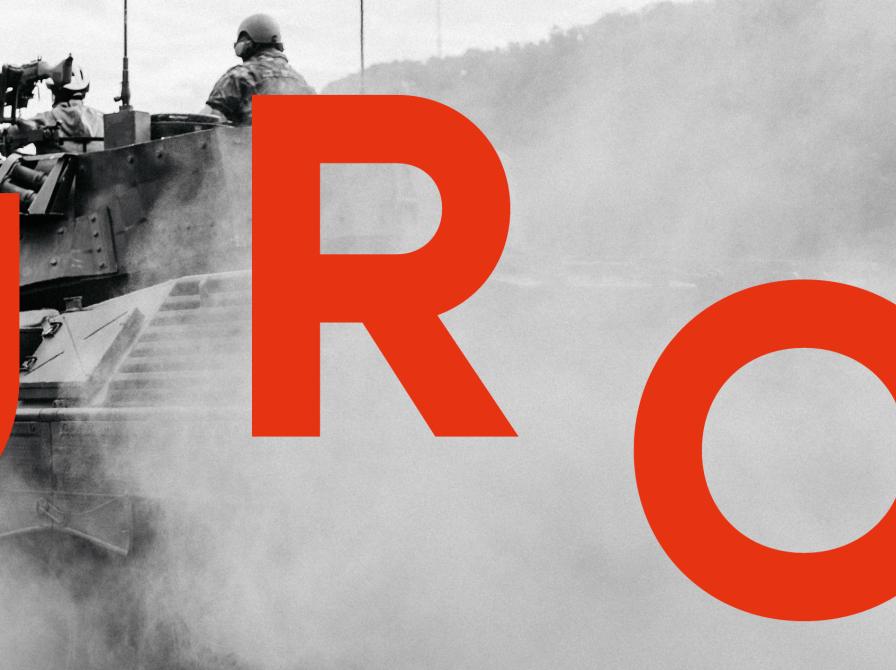 Billede med teksen URO skrevet med rød skrift over et sort/hvid foto af en tank af en 