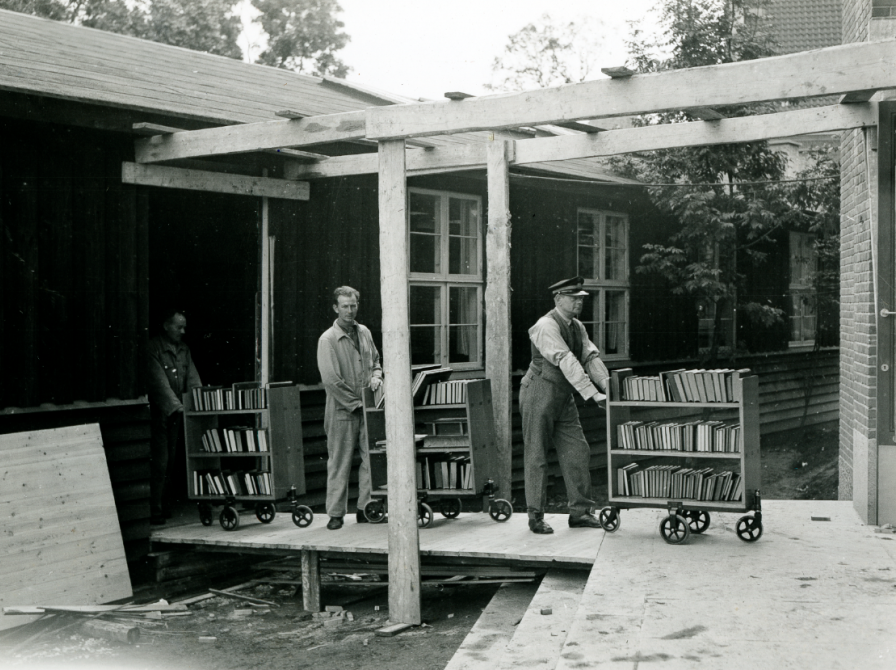 Sort hvidt foto af betjente som skubber bogvogne på Frederiksberg i 1935