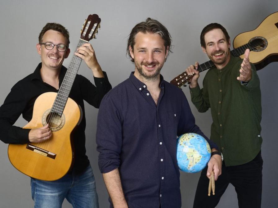 3 smilende mænd med to spanske guitarer og en jordklode.