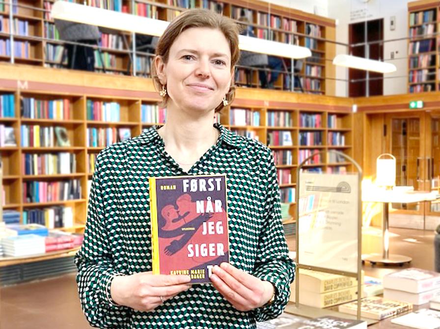 Bibliotekar stående med bogen Først når jeg siger