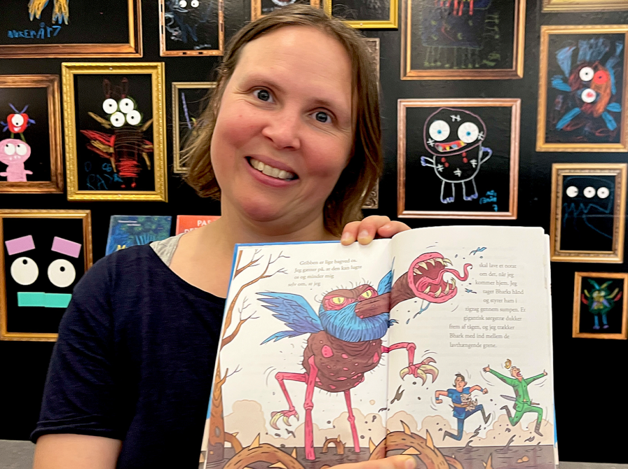 biblioteker holder bog, der er slået op på en monstertegning