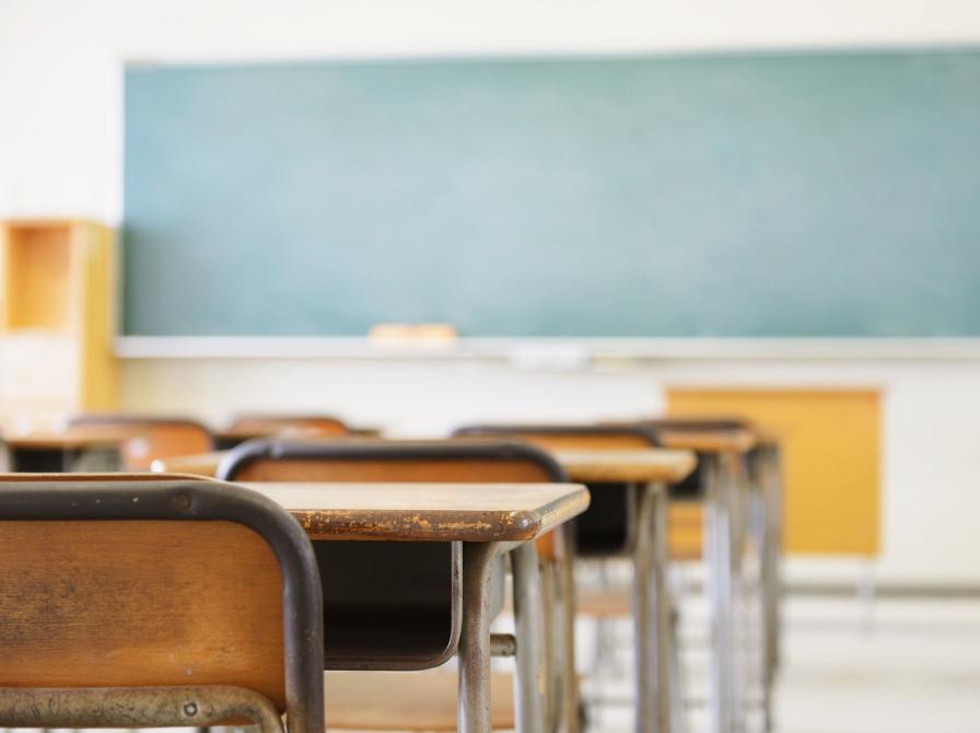 Tomt klasselokale med stole, borde og tavle