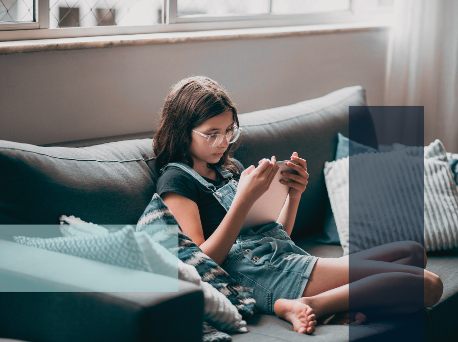 teenager i sofa læser på ipad