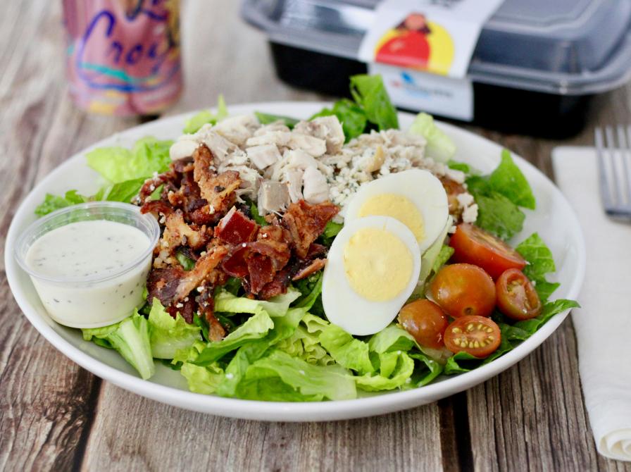 billede af tallerken med æg og bacon og tomat på bund af salat
